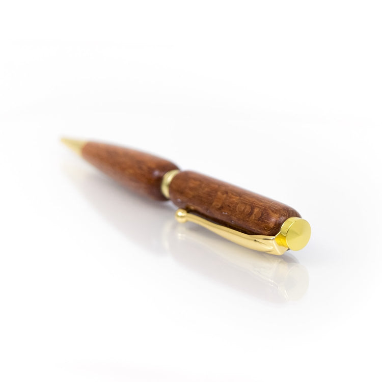 Handcrafted Lacewood pen with light reddish-brown grain, glossy finish, and refillable black ballpoint ink insert, made in Missouri