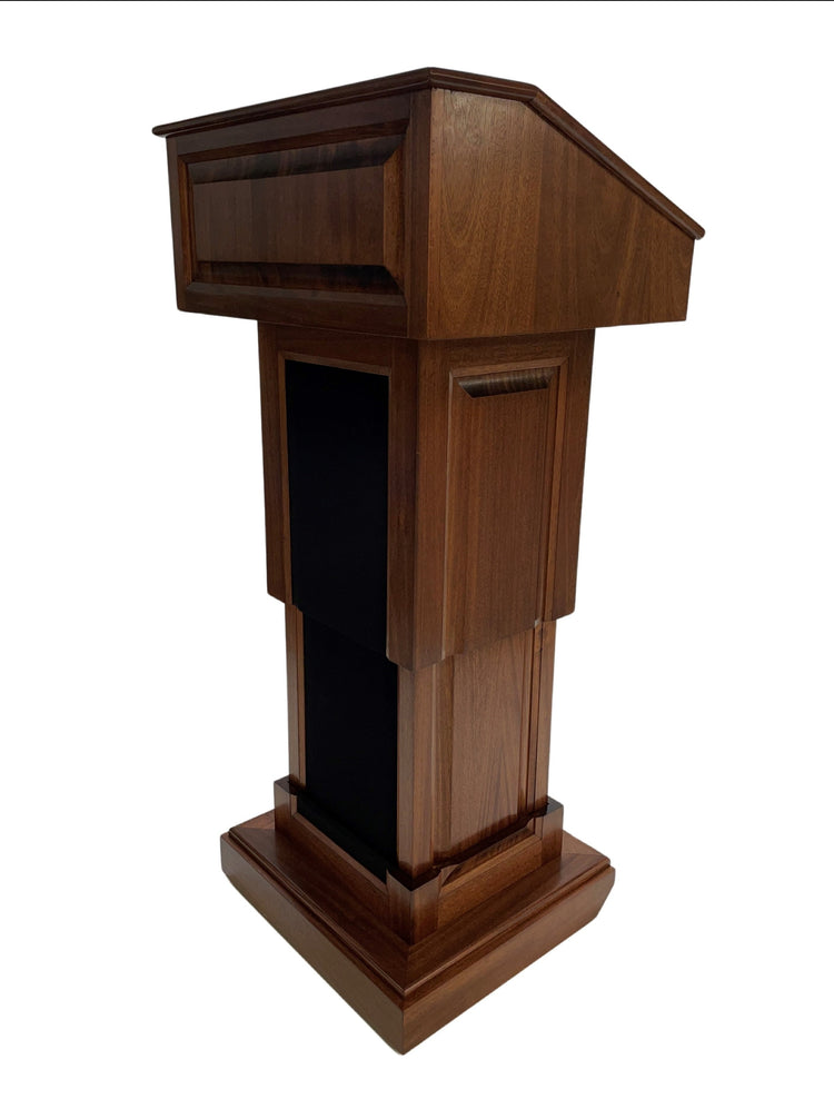 The Counselor Evolution Lift™ lectern, handcrafted from mahogany wood, features adjustable height, built-in sound system, and mobility casters.