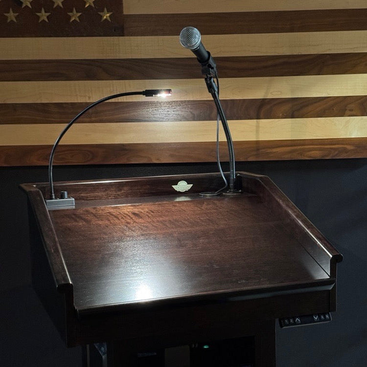 Wooden podium with microphone against an American flag background