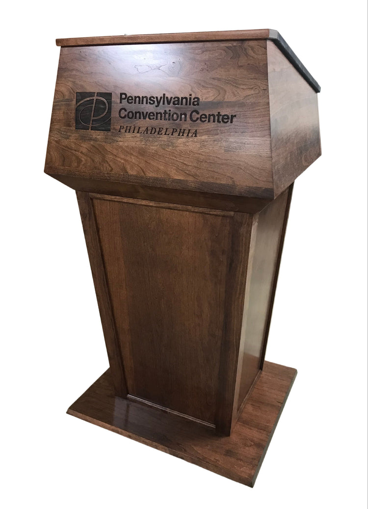 "Presidential™ Solid Hardwood Podium featuring a sleek, classic design with rich wood finish. The podium is crafted from solid hardwood, providing a sturdy and elegant stand for presentations, speeches, and lectures. Ideal for professional settings like conferences, universities, and executive meetings. TEXTILE FABRIC COVERING TOP SEAMLESS AMERICAN MADE HANDCRAFTED LECTERN MOBILE