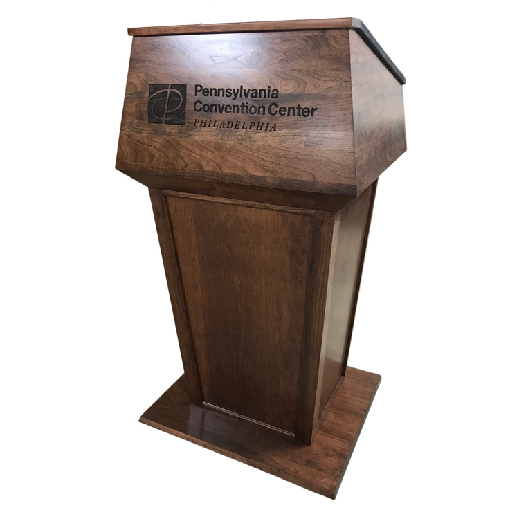"Presidential Plus™ Large Solid Wood Podium featuring a rich, polished finish and spacious design. Crafted from high-quality solid wood, this elegant podium offers ample surface area for presentations, with a classic and professional look perfect for corporate, academic, or formal settings." PODIUM SOUND SYSTEM AMERICAN MADE PODIUM handcrafted podium