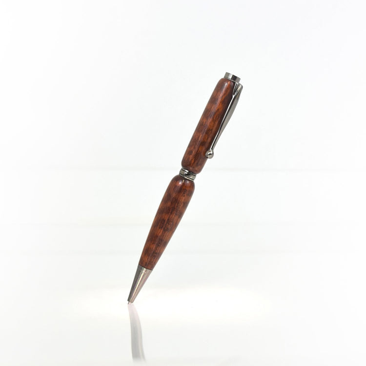 Handcrafted Snakewood pen with scaly grain, glossy finish, and refillable black ballpoint ink insert