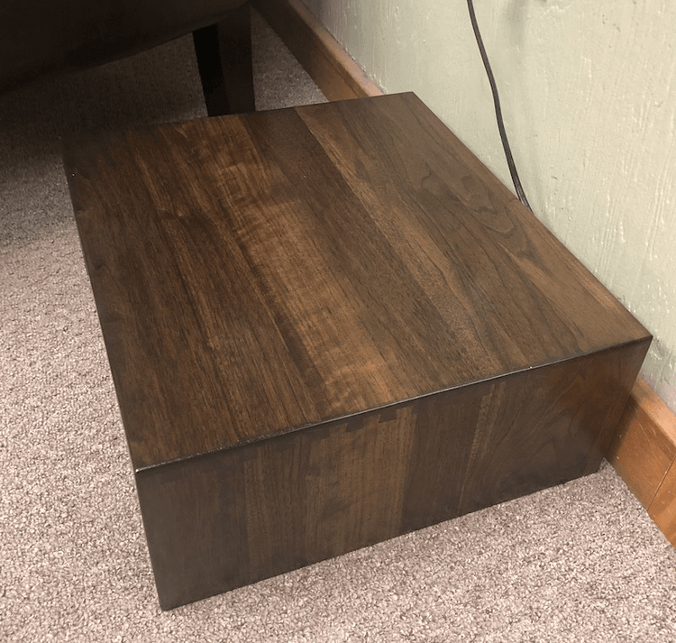 Solid hardwood robot vacuum cover with dovetail joinery, open-back design for easy docking, and optional tile top inlay. Made in the USA.