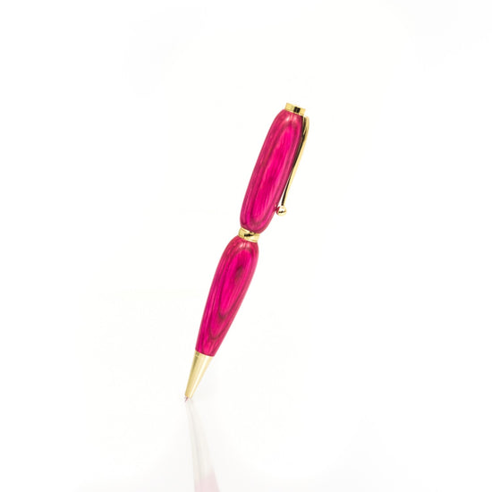 Handcrafted pink wood pen with high-gloss finish and refillable black ballpoint ink, made in Missouri