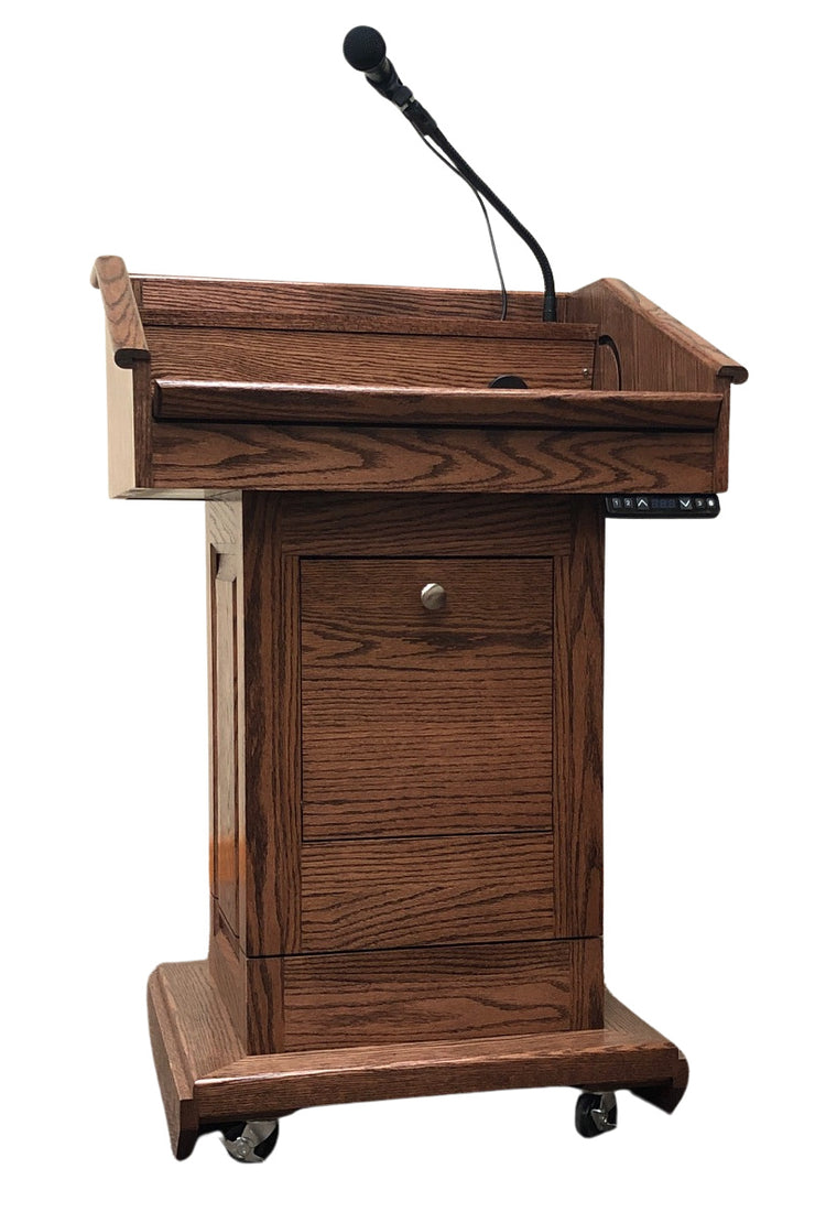 The Counselor Evolution Lift™ lectern, handcrafted from oak wood, features adjustable height, built-in sound system, and mobility casters.