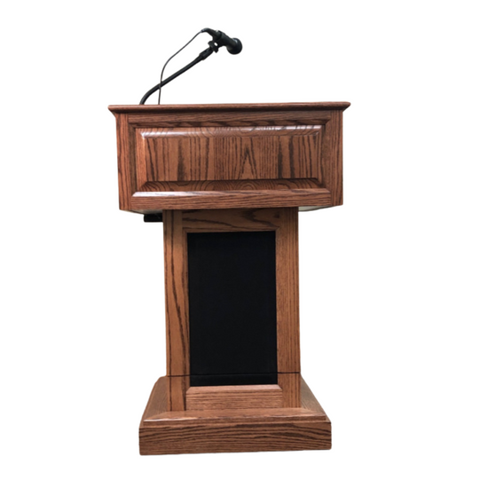 The Counselor Evolution Lift™ podium, handcrafted from premium wood, features power adjustable height, built-in sound system, and casters.