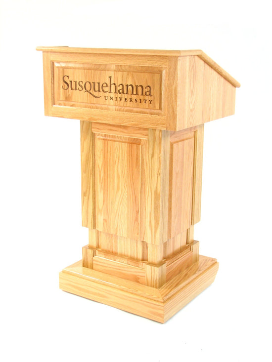 Counselor Lift™ Oak Podium with electric height adjustment, premium hardwood, and mobility casters with an engraving.