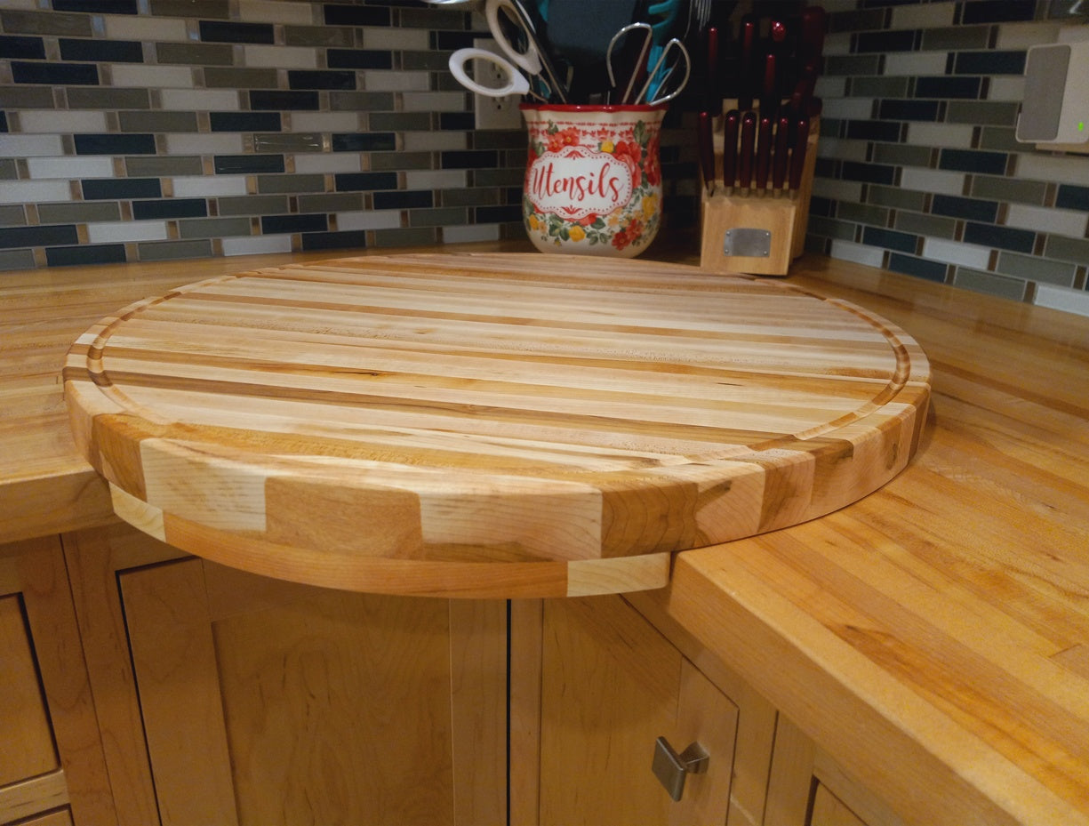 Large round corner cutting board with drip rail, handcrafted from solid maple. Designed for easy cleanup.