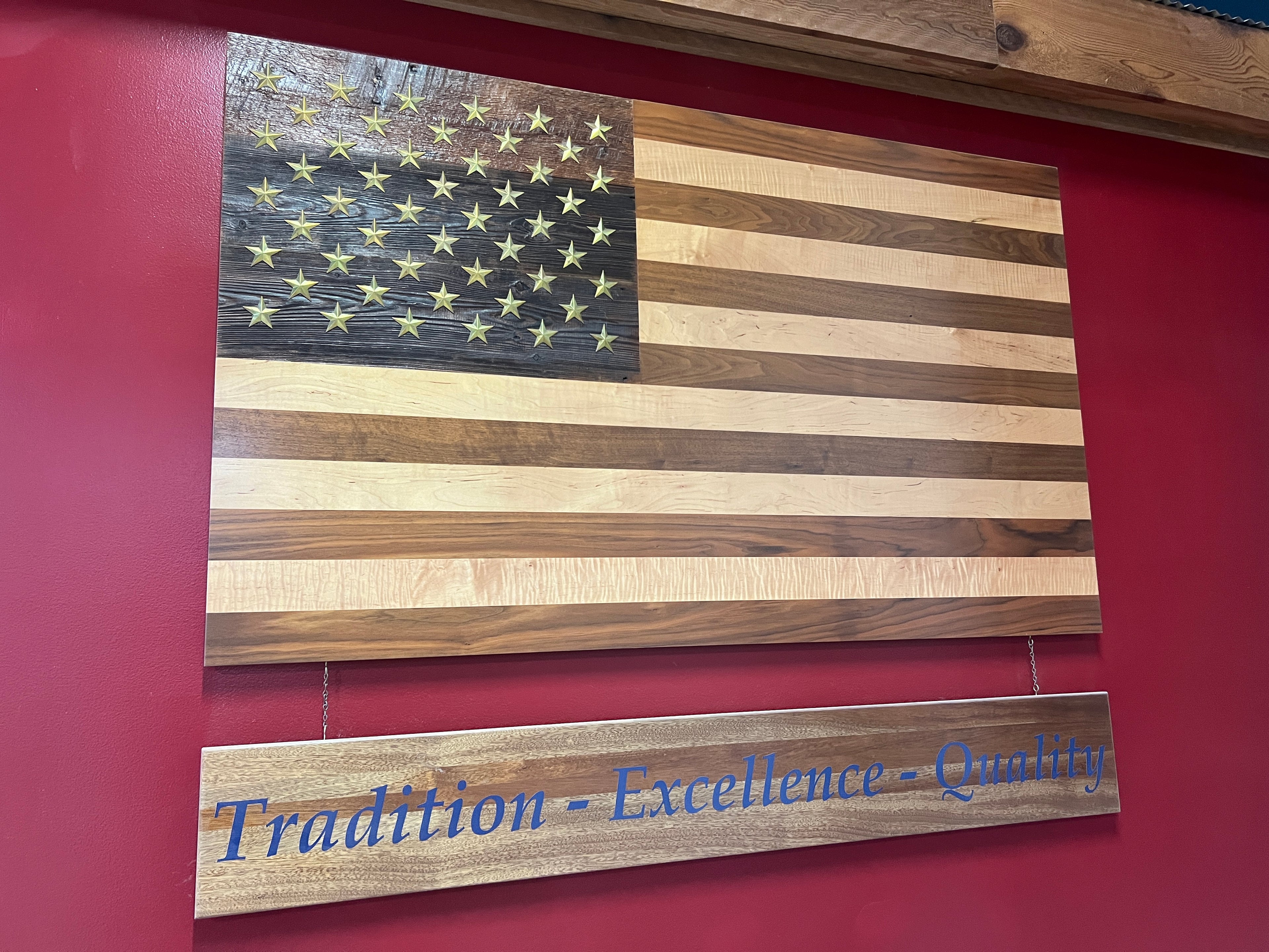 Handcrafted solid wood American flag with walnut and maple stripes, brass stars, and a reclaimed barn wood star background.