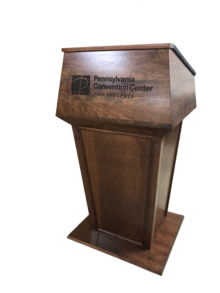 "Presidential™ Solid Hardwood Podium featuring a sleek, classic design with rich wood finish. The podium is crafted from solid hardwood, providing a sturdy and elegant stand for presentations, speeches, and lectures. Ideal for professional settings like conferences, universities, and executive meetings. TEXTILE FABRIC COVERING TOP SEAMLESS AMERICAN MADE HANDCRAFTED LECTERN MOBILE