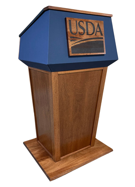 "Presidential™ Solid Hardwood Podium featuring a sleek, classic design with rich wood finish. The podium is crafted from solid hardwood, providing a sturdy and elegant stand for presentations, speeches, and lectures. Ideal for professional settings like conferences, universities, and executive meetings. TEXTILE FABRIC COVERING TOP SEAMLESS AMERICAN MADE HANDCRAFTED LECTERN MOBILE