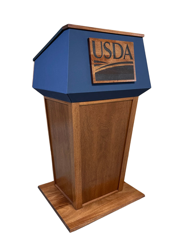 "Presidential™ Solid Hardwood Podium featuring a sleek, classic design with rich wood finish. The podium is crafted from solid hardwood, providing a sturdy and elegant stand for presentations, speeches, and lectures. Ideal for professional settings like conferences, universities, and executive meetings. TEXTILE FABRIC COVERING TOP SEAMLESS AMERICAN MADE HANDCRAFTED LECTERN MOBILE