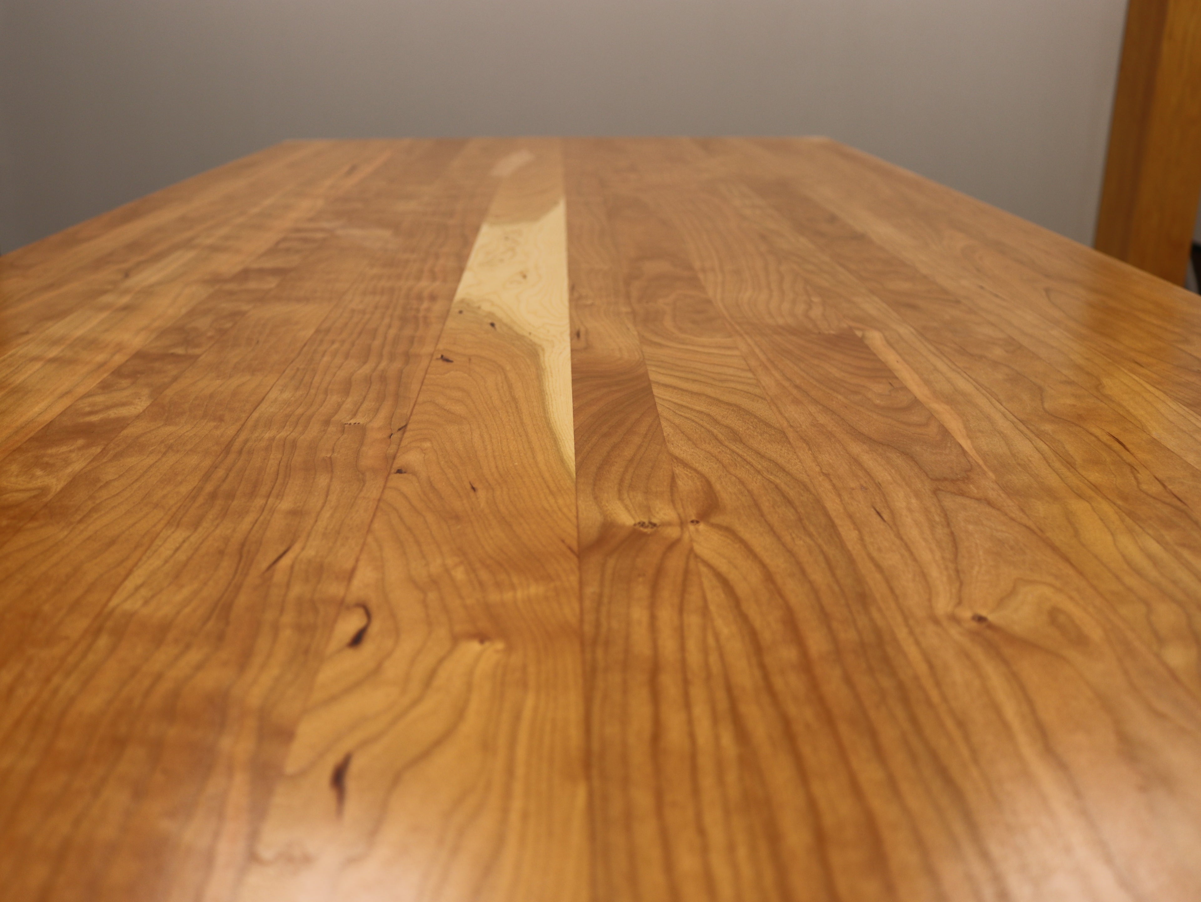 Handcrafted executive office table featuring a luxurious solid cherry wood top. The table showcases a smooth, rich cherry finish with intricate wood grain details, perfect for adding a timeless and professional touch to any office space. american made durable steady