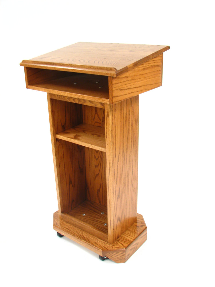  "Senator™ Solid Hardwood Podium, featuring a sleek design made from durable solid wood. It includes a spacious work surface, hidden rear casters for easy mobility, and ample storage space for supplies. Perfect for schools, churches, and event venues." American made craftsmanship Lectern