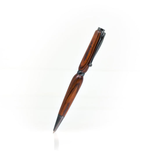 Handcrafted Cocobolo pen with dark red wood grain, glossy finish, and refillable black ballpoint ink insert, made in Missouri