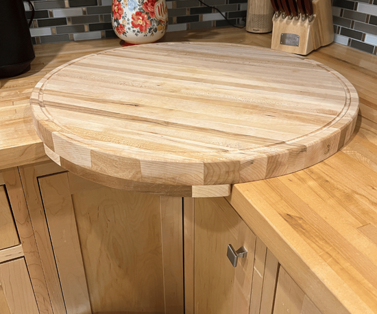 Large round corner cutting board with drip rail, handcrafted from solid maple. Designed for easy cleanup.