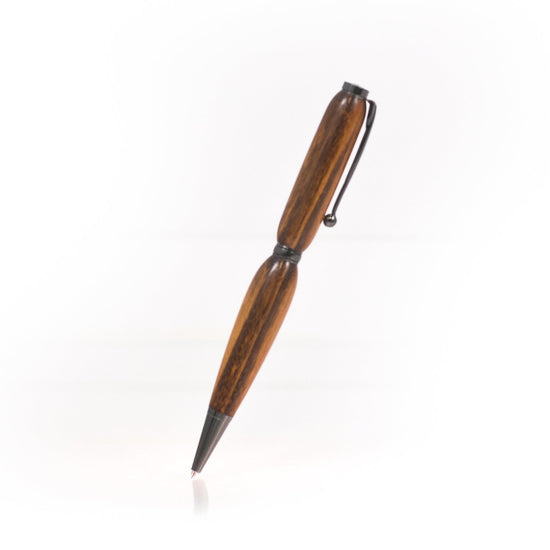 Handcrafted Tigerwood pen with deep reddish tones and dark stripes, glossy finish, refillable black ballpoint insert, made in Missouri