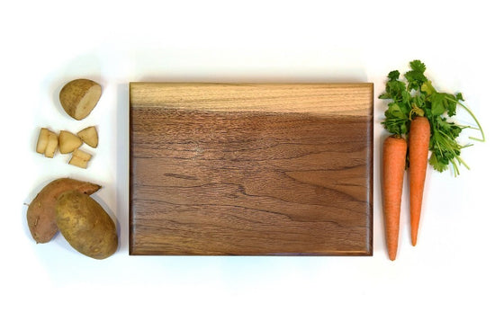 Handmade walnut cutting board with recessed handles and non-slip rubber feet
