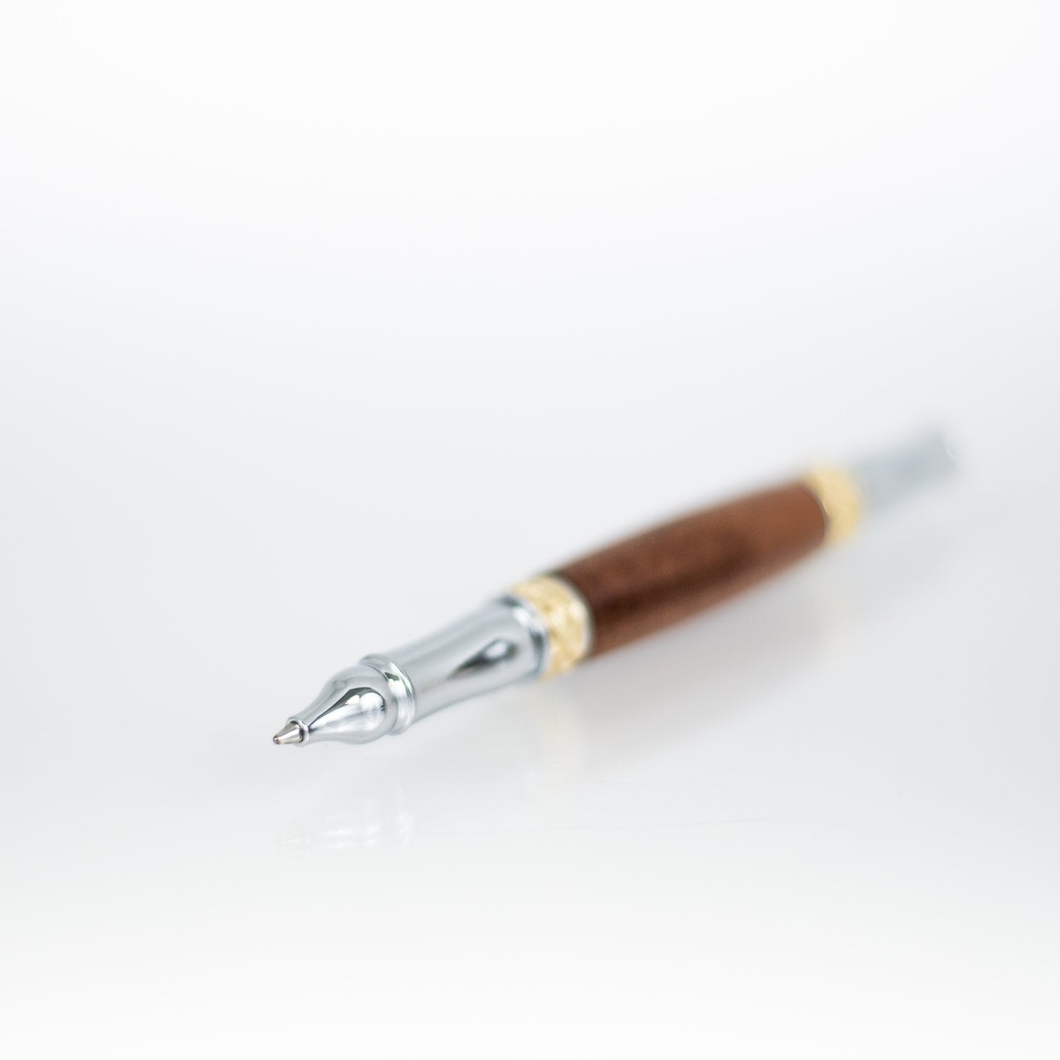 Handcrafted walnut rollerball pen with 24K gold accents and metal body