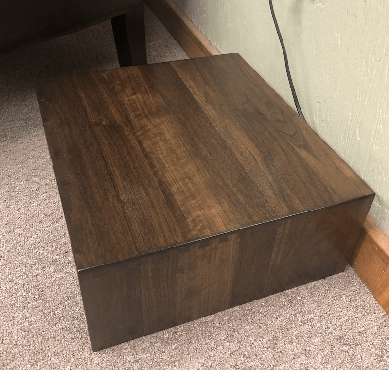 Solid hardwood robot vacuum cover with dovetail joinery, open-back design for easy docking, and optional tile top inlay. Made in the USA.