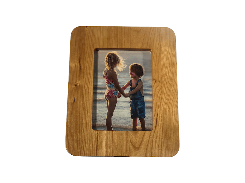 SmartFrame™ wood charging station holds a 5x7 photo, wirelessly charges phones & watches, and amplifies sound. Made in USA.